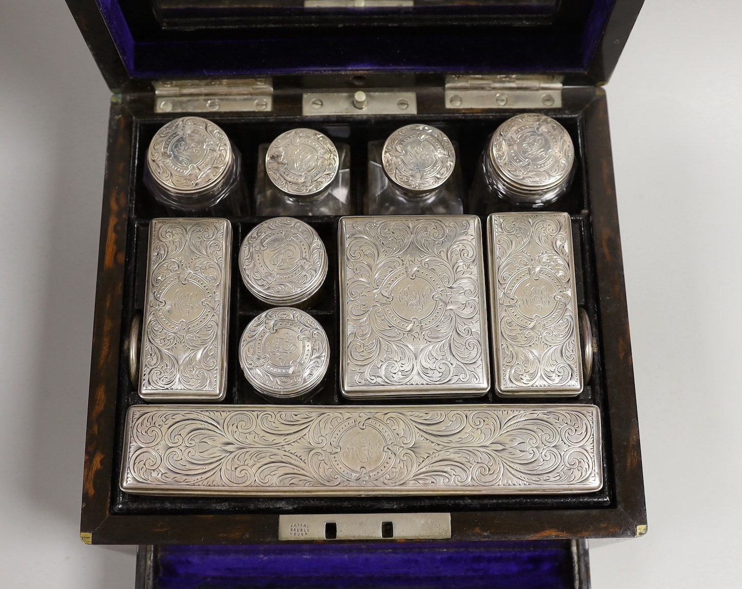 A late Victorian Mappin & Webb coromandel wood toilet box, containing ten silver mounted toilet jars, George Betjemann & Sons, London, 1895, box 21.2cm, mechanism for drawer a.f.